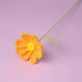 Handmade crochet cosmos flower detail showing delicate orange petals and green stem texture. - Orange