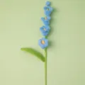 Handgemaakte gehaakte blauwe bloem close-up detail, wol gebreide botanische decoratie. - Blauw