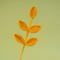 Close-up detail van handgemaakte gele gehaakte vijfbladige tak, prachtig wollen handwerk. - Gembergeel