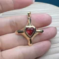 Nahaufnahme eines goldenen Kreuz Herz Zirkon Anhängers, ideal für DIY Schmuck und stilvolle Ketten. - Rot
