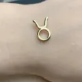 Primo piano dettagliato del ciondolo zodiacale Toro placcato in oro sulla pelle, lucido. - Taurus