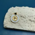 Dettaglio pendente Madonna dorata, cerchio smalto bianco, accessorio rilievo metallo. - Stile B