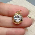 Detailed macro view of a minimalist gold heart zircon charm for DIY jewelry making. - White