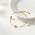 Gold plated titanium steel floral daisy bracelet detail view, elegant minimalist jewelry accessory. - Bracelet