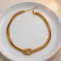 Gold metal knot chain necklace for women, stylish geometric choker jewelry detail view. - Necklace / Gold Necklace