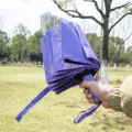 Portable folding umbrella, purple compact design for rain and sun protection outdoor use. - Purple