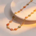Close-up detail shot of the colorful daisy enamel titanium steel necklace with floral charms. - Colorful Daisy Necklace Gold