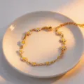 Gold titanium steel daisy chain bracelet with white and yellow enamel flower charms for women. - White Daisy Bracelet Gold