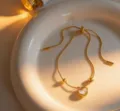 Exquisite titanium steel gold chain bracelet featuring a delicate white shell heart pendant detail. - White Bracelet