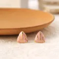 Detail shot of pink triangular geometric titanium steel stud earrings with gold trim. - Pink