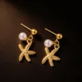 Gold starfish pearl earrings detail shot showcasing delicate ocean beach vacation jewelry design. - Earrings