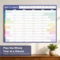 Detailed view of the 2027 wall planner hanging in a neat room setup with a small green plant. - 2027 Calendar Posters - Dark Blue No. 14