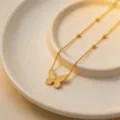 Exquisite gold-colored titanium steel butterfly pendant necklace with delicate beaded chain details. - Butterfly Necklace