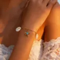 Close-up of golden shell and starfish charm bracelet, perfect beach holiday wrist accessory. - Bracelet