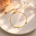 Gold titanium steel cross bracelet detail shot, elegant minimalist luxury fashion accessory. - Bracelet / Gold