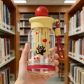 Süße Plastikwasserflasche mit Katzen-Cartoon, Strohhalm und roter Trageschlaufe - Kugeldeckel - Rot (mit Tragekordel & Teefach)