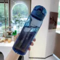 Blaue Kunststoff-Sportwasserflasche mit Tragegriff und Strohhalm für Fitness und Alltag. - Transparentes Blau