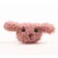 Detailopname van de pluizige roze puppy pluche charm met krullend bont en schattig gezicht. - Puppykop / Zonder Broche / Oudroze