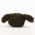 Detail van schattige bruine pluche hond, zachte donzige knuffelbedel voor tassen en accessoires. - Legergroen