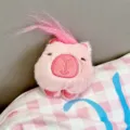 Ciondolo capibara in peluche rosa con capelli lunghi, simpatico peluche vista dettagliata. - Stile Catena Sospesa / Capibara Rosa Frontale