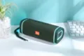 Tragbarer Bluetooth Lautsprecher mit Stoffbezug, bunten LED-Lichtringen und praktischer Trageschlaufe. - Grün