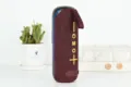 Haut-parleur Bluetooth portable en tissu élégant avec sangle de transport pratique pour l'extérieur. - Bordeaux