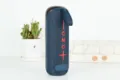 Haut-parleur Bluetooth portable avec tissu bleu foncé et boutons rouges, vue détaillée. - Bleu