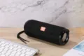 Tragbarer kabelloser Bluetooth-Lautsprecher im schwarzen Stoffnetz-Design mit Trageschlaufe. - Schwarz