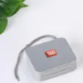 Grauer tragbarer Bluetooth Lautsprecher mit praktischer Trageschlaufe und Stoffdesign für Musik. - Grau