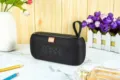 Detailaufnahme tragbarer schwarzer Bluetooth-Lautsprecher auf Marmortisch mit Blumen. - Schwarz