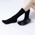 Black five-toe grip socks for yoga and pilates, featuring anti-slip dots for stability. - One Size / Black