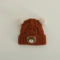 Cute bear patch detail of baby knit hat, fluffy pom poms, warm winter earflap beanie detail - Suggested 1-3 Years (46-50cm) / Brick Red
