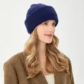 Primo piano di un comodo berretto in maglia blu scuro indossato da una modella. - M (54-58cm) / Blu navy
