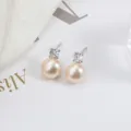 Klassische Süßwasserperlen Ohrringe mit 925er Silber Nadel und funkelnden Zirkonia Steinen. - Silberne Basis / Natürliches Rosa Orange
