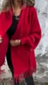 Close-up detail of the red imitation mink cashmere poncho with stylish fringe and batwing design. - S / Tops / Red