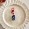 Cute cartoon black cat keychain with red hat and hook, perfect bag pendant accessory gift. - Sleeping Black Cat
