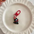 Cute cartoon black cat keychain detail shot, red clasp, premium metal and enamel material. - Jumping Black Cat