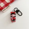 Close-up detail of the gothic cartoon girl keychain pendant with black metal hardware clasp. - Dark Girl - Holding Doll
