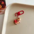 Close-up detail of cute cartoon horse keychain charm with red clasp for bag decoration. - Horse - Firecracker