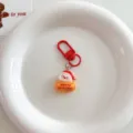 Close-up detail view of a cute cartoon Santa Claus keychain with red hook and festive design. - Cute Christmas Pendant - Santa Claus