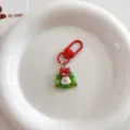 Close-up of a cute Christmas Santa Claus keychain with red clasp and wreath pendant. - Cute Christmas Pendant - Wreath