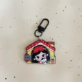 Cute big-eyed girl acrylic keychain detail showing the adorable cartoon house pendant design. - Big-Eyed Girl - Red House