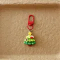 Nahaufnahme des niedlichen Weihnachtsbaum Taschenanhängers mit rotem Karabiner und Dekor. - Weihnachtsbaum