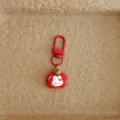 Close-up detail of the cute apple rabbit keychain and red metal clasp pendant ornament. - Apple
