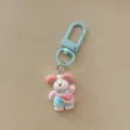 Cute cartoon puppy keychain detail shot, pink and white dog pendant with blue clasp. - Overall Pants Dog / Light Blue