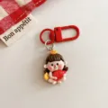 Adorable cartoon doll keychain detail showing red metal clasp and cute lucky figurine. - Fortune Doll Holding Fish