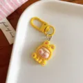 Détail de porte-clés dessin animé jaune mignon, pendentif d'accessoire de sac en résine fine. - Jaune