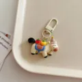 Detail shot of cute cartoon horse keychain with fruit charm and metal clasp pendant ornament. - Beige
