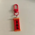Gros plan détaillé du porte-clés rouge du Nouvel An avec un pendentif décoratif enroulé. - Plaque de Couplet - Duo Xi Le