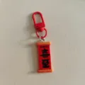 Close-up detail of the Chinese style red scroll keychain with festive characters and metal hook. - Couplet Board - Xi Zhi